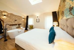 a bedroom with a large bed and a bath tub at Il Vicolo Suite Apartments - La Piazzetta- Roof Terrace in Tignale