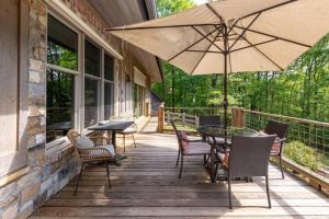 een patio met een tafel en stoelen en een parasol bij The Poet's House, Luxury and Solitude on 100 acres in Lewisville