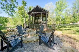 a gazebo with three blue chairs in a yard at Farmhouse Tiny home with fishing Pond - Oak Cabin in Gatlinburg
