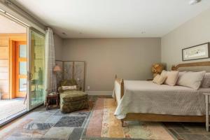 een slaapkamer met een bed, een stoel en een raam bij The Poet's House, Luxury and Solitude on 100 acres in Lewisville