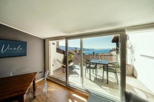 a room with a balcony with a table and chairs at Il Vicolo Suite Apartments - La Piazzetta- Roof Terrace in Tignale
