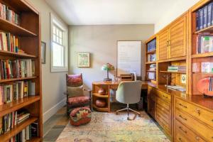 een kantoor met een bureau, een stoel en boekenplanken bij The Poet's House, Luxury and Solitude on 100 acres in Lewisville