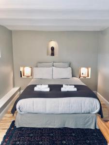 1 dormitorio con 1 cama grande y 2 toallas. en Les Grands Jardins Lodge, en Giverny