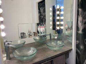 a bathroom with four glass bowl sinks on a counter at Maison d'artistes avec vue panoramique sur la baie in Toulon