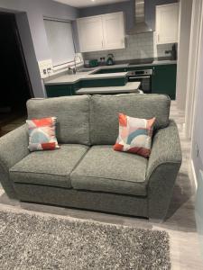 a gray couch with two pillows in a kitchen at Ty Haf in Aberdare