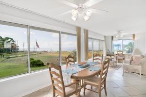 a dining room with a table and chairs and a large window at Southern Island Charm in Dauphin Island