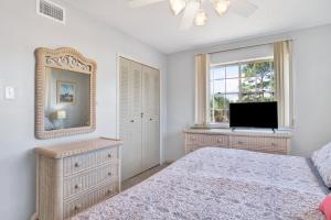 a bedroom with a bed and a mirror and a television at Southern Island Charm in Dauphin Island +22 photos
