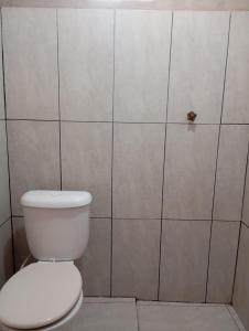 łazienka z toaletą i ścianą wyłożoną kafelkami w obiekcie HOSPEDARIA ITAPUÃ w mieście Santarém