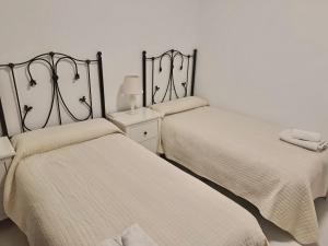 twee bedden naast elkaar in een slaapkamer bij Apartamento El Primer Sol in Nerja