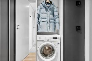 a coat sitting on top of a washing machine at Studioleilighet, uten soverom in Bodø