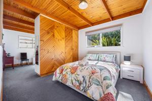 a bedroom with a bed and a wooden ceiling at Ballarat Cottages in Ballarat