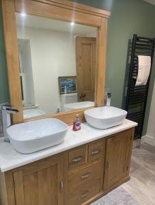 baño con 2 lavabos y espejo grande en ISLE OF GIGHA FARM HOUSE en Ardminish