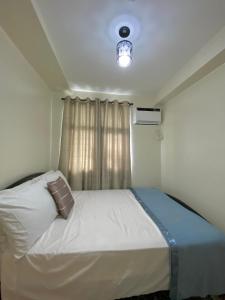 1 dormitorio con 1 cama con luz en el techo en Seawind by the ocean, en Davao City