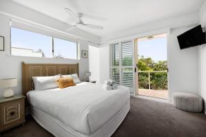 a bedroom with a large white bed and a window at 7 28 Duke Street Sunshine Beach in Sunshine Beach +6 photos