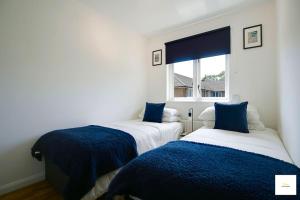 two beds in a room with a window at Beautiful City Centre Aprt/Sleeps 8/W Parking in Southampton