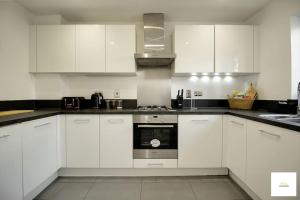 a kitchen with white cabinets and a stove top oven at Beautiful City Centre Aprt/Sleeps 8/W Parking in Southampton