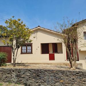 une maison blanche avec des arbres devant elle dans l'établissement Pertim da Serra, à Catas Altas