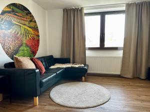 a living room with a blue couch and a rug at SPEYERBACH - modernes Apartment nahe Neustadter Innenstadt in Neustadt an der Weinstraße