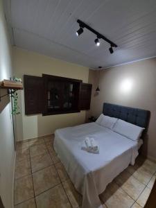 Pertim da Serra في كاستاس ألتاس: غرفة نوم عليها سرير وحذيين