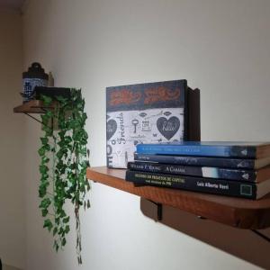 a stack of books sitting on a shelf at Pertim da Serra in Catas Altas
