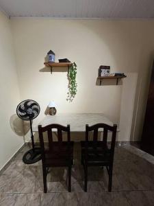 a table with two chairs and a table with a plant at Pertim da Serra in Catas Altas