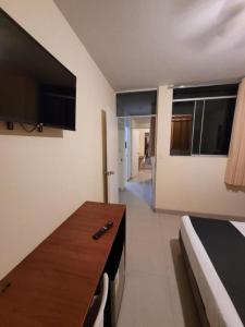 ピウラにあるConde Hotel Mirafloresのデスクとベッドが備わる客室です。