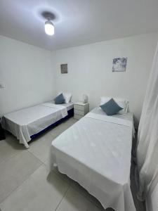 - 2 lits dans une chambre aux murs blancs dans l'établissement Alojamiento en San Juan Opico, à San Juan Opico