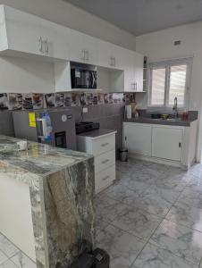cocina con armarios blancos y suelo de mármol en Apartamento en Miraflores, en Tegucigalpa