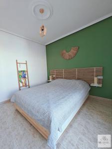 a bedroom with a bed and a green wall at Casa Miramar in Ciudad Quesada