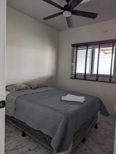 a bedroom with a bed with a ceiling fan at Apartamento en Miraflores in Tegucigalpa