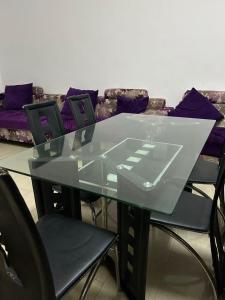 a glass table with four chairs and a couch at Seaside master bedroom in Sharjah