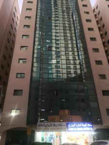 a tall building with a sign in front of it at Seaside master bedroom in Sharjah