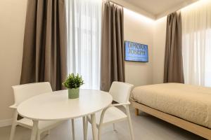 a bedroom with a white table and chairs and a bed at Dimora Joseph VIA TOLEDO in Naples