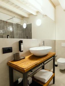 uma casa de banho com um lavatório e um WC em Il Vicolo Suite Apartments - Il Corso em Tignale