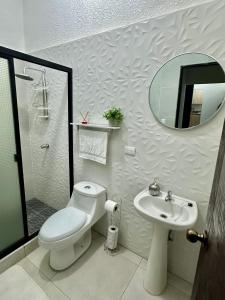 La salle de bains est pourvue de toilettes, d'un lavabo et d'un miroir. dans l'établissement Alojamiento en San Juan Opico, à San Juan Opico