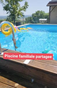 ein großer Pool mit einem plasticennaulischen Paradieseschild darin in der Unterkunft Domaine de la Crête . Suite COSY Les CoCottes ZEN in Saint-Jean-de-Thurac