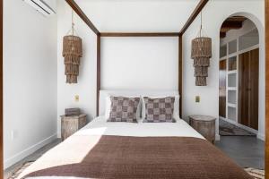 1 dormitorio con 1 cama blanca grande con almohadas en Moroccan Swim House- Joshua Tree Mia Riad, en Yucca Valley