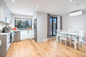 cocina y comedor con mesa y sillas en Two-bedroom flat near Wembley, London en Wealdstone