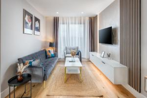 a living room with a couch and a tv at Two-bedroom flat near Wembley, London in Wealdstone