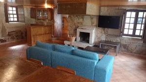 sala de estar con sofá azul y chimenea en Solar da Benedita, 