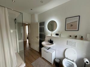 a bathroom with a toilet and a sink and a mirror at Haus Newgate in Lübeck