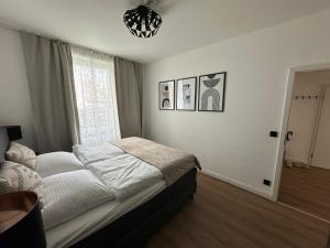 a bedroom with a bed and a window and a chandelier at Haus Newgate in Lübeck