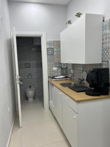 eine weiße Küche mit einem Waschbecken und einem WC in der Unterkunft La Casa di Manila in Neapel