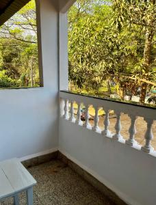 a window with a white railing next to a table at Shenvi Homestay Old Goa in Panaji