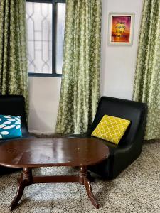 a living room with a coffee table and a chair at Shenvi Homestay in Panaji