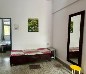 a bedroom with a bed and a mirror at Shenvi Homestay - Near Old Goa Churches & Karmali Railway Station, Old Goa in Old Goa +2 photos
