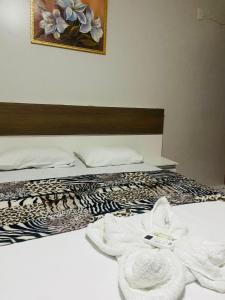 Hotel Brasília Park في Novo Gama: غرفة نوم عليها سرير وفوط