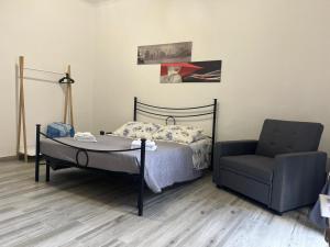 un letto e una sedia in una stanza di Ortigia Home a Siracusa