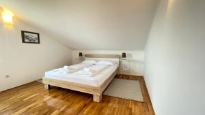 um quarto com uma cama branca num sótão em Apartment More em Jadranovo