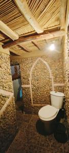 a bathroom with a toilet in a stone wall at Riad DAR outebba 
